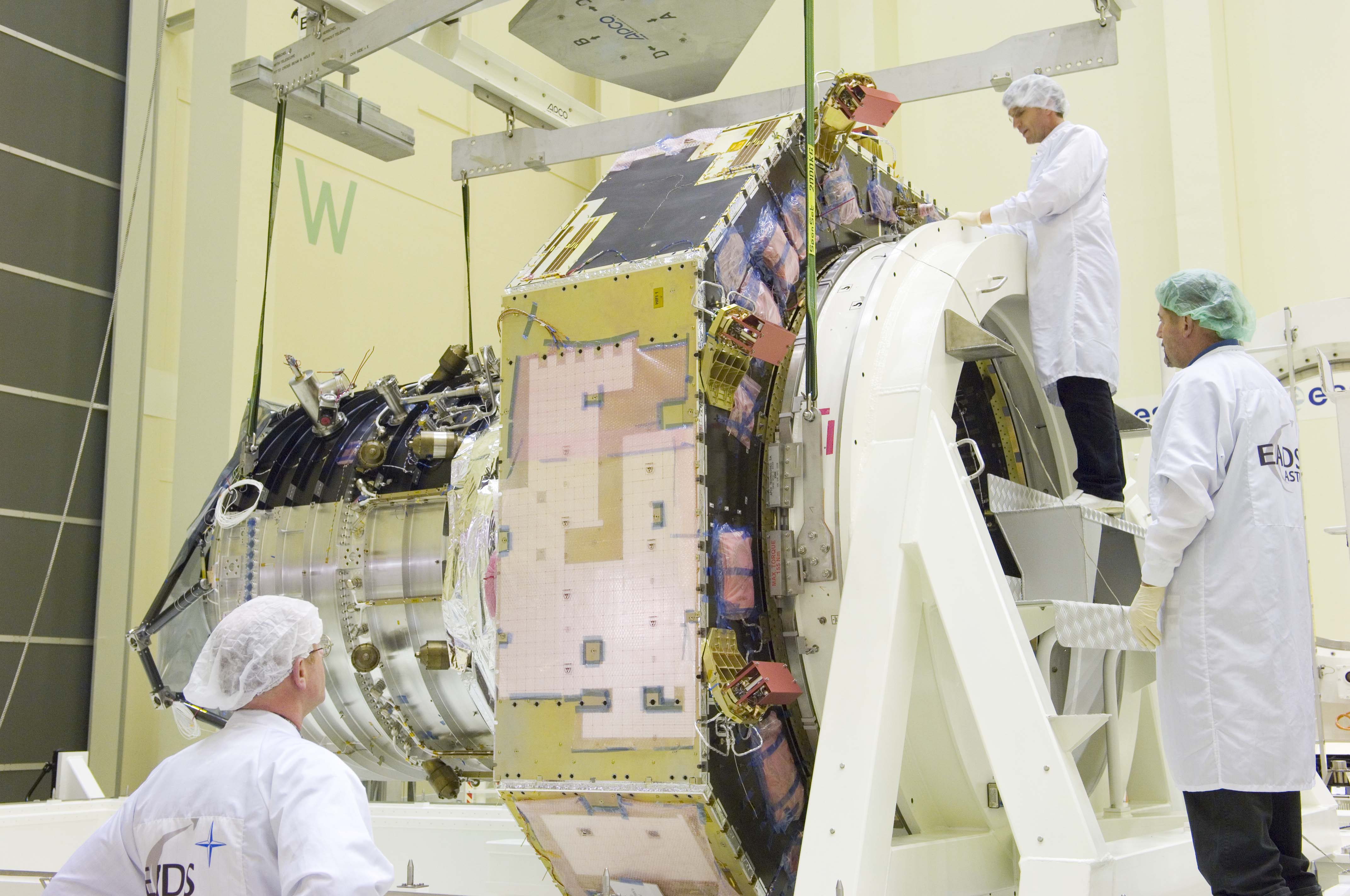 The Herschel Flight Model spacecraft is prepared for being lifted from its transport container.