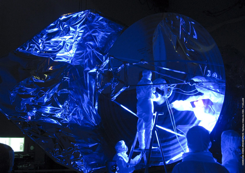 Herschel's 3.5-meter-diameter mirror is checked using ultraviolet light in the S1B clean room at Europe's Spaceport